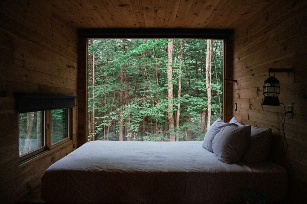 Cabaña de madera con ventanal hacia el bosque