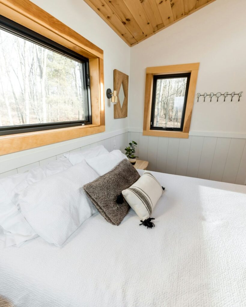 Habitación luminosa con cielo raso de madera y ropa de cama blanca