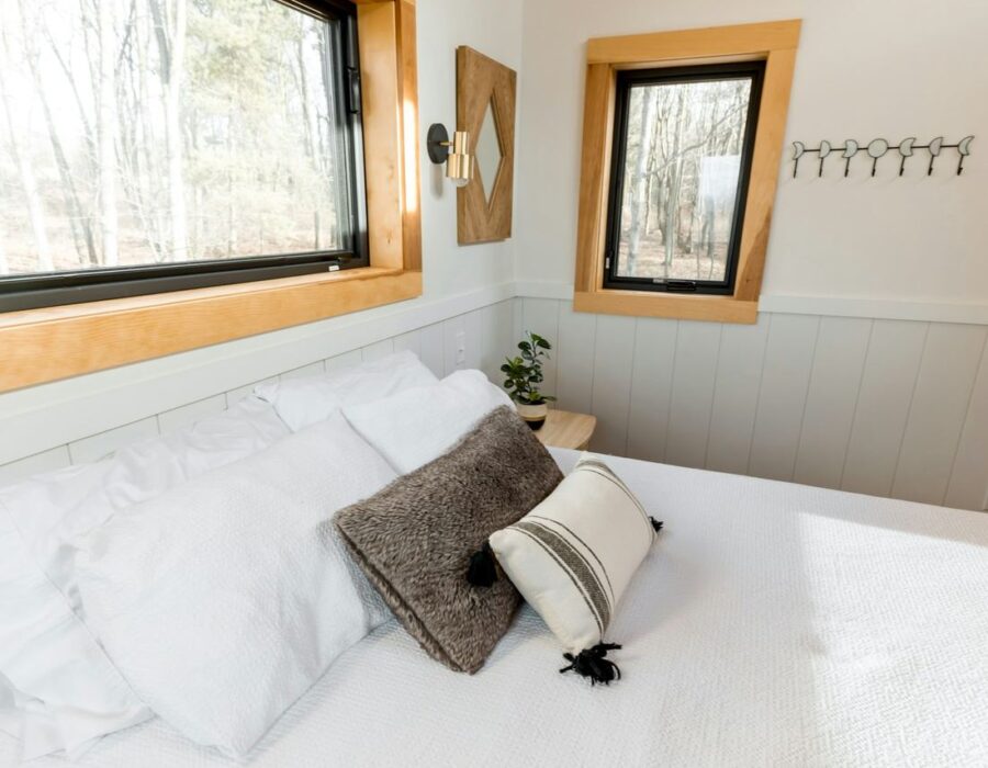 Habitación luminosa con cielo raso de madera y ropa de cama blanca