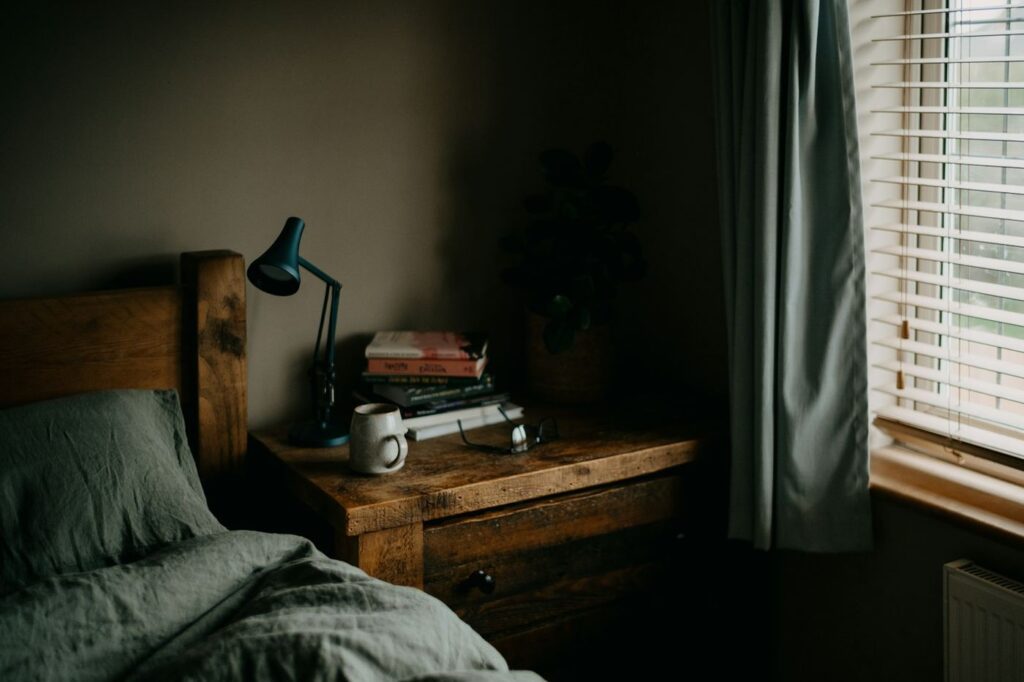 Habitación acogedora con cama de madera y lámpara de lectura