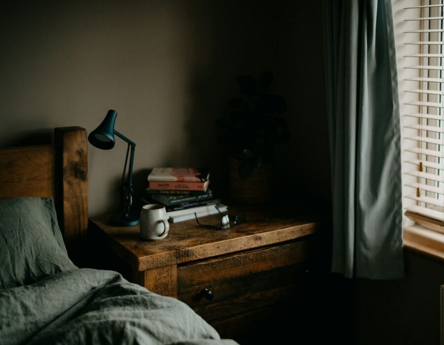Habitación acogedora con cama de madera y lámpara de lectura
