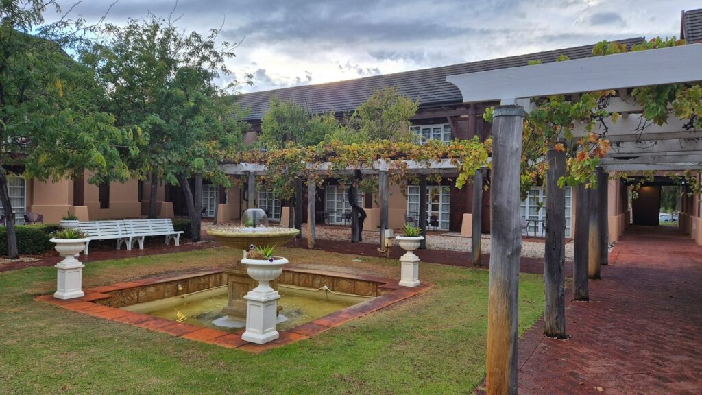 Jardín con fuente y pérgola de un patio de hotel