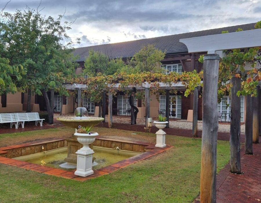 Jardín con fuente y pérgola de un patio de hotel