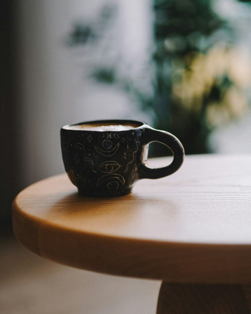 Taza de café sobre una mesa redonda de madera